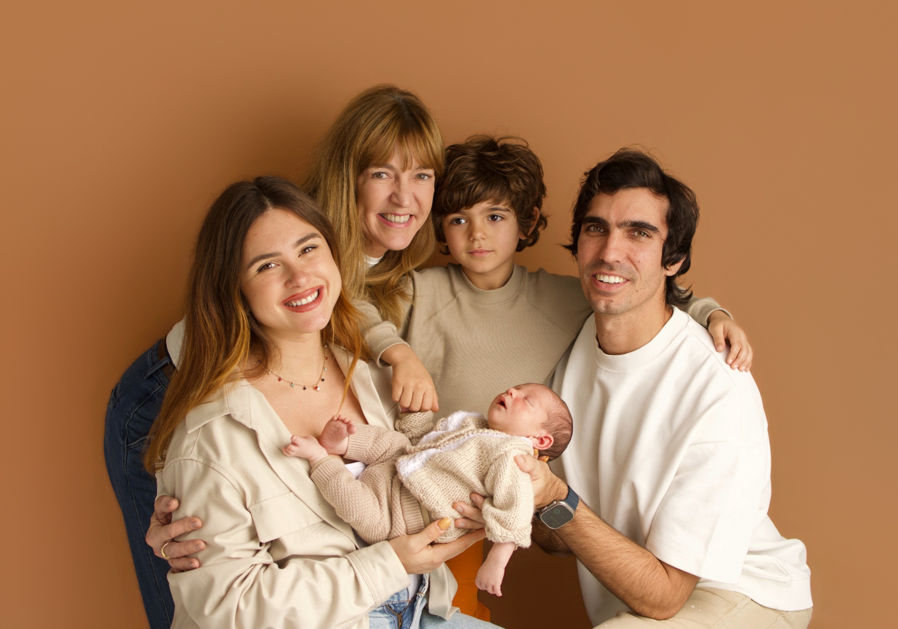 Parent holding a newborn in soft window light during an in-home newborn photography session