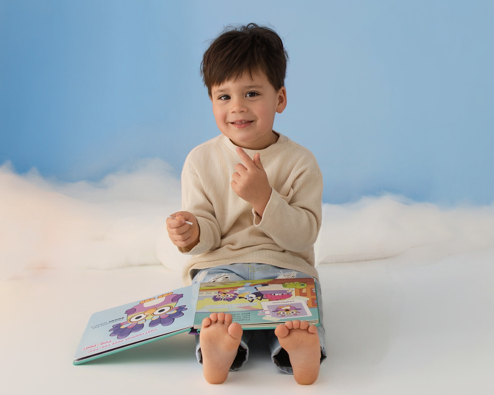 Toddler celebrating a birthday milestone with a book and cake
