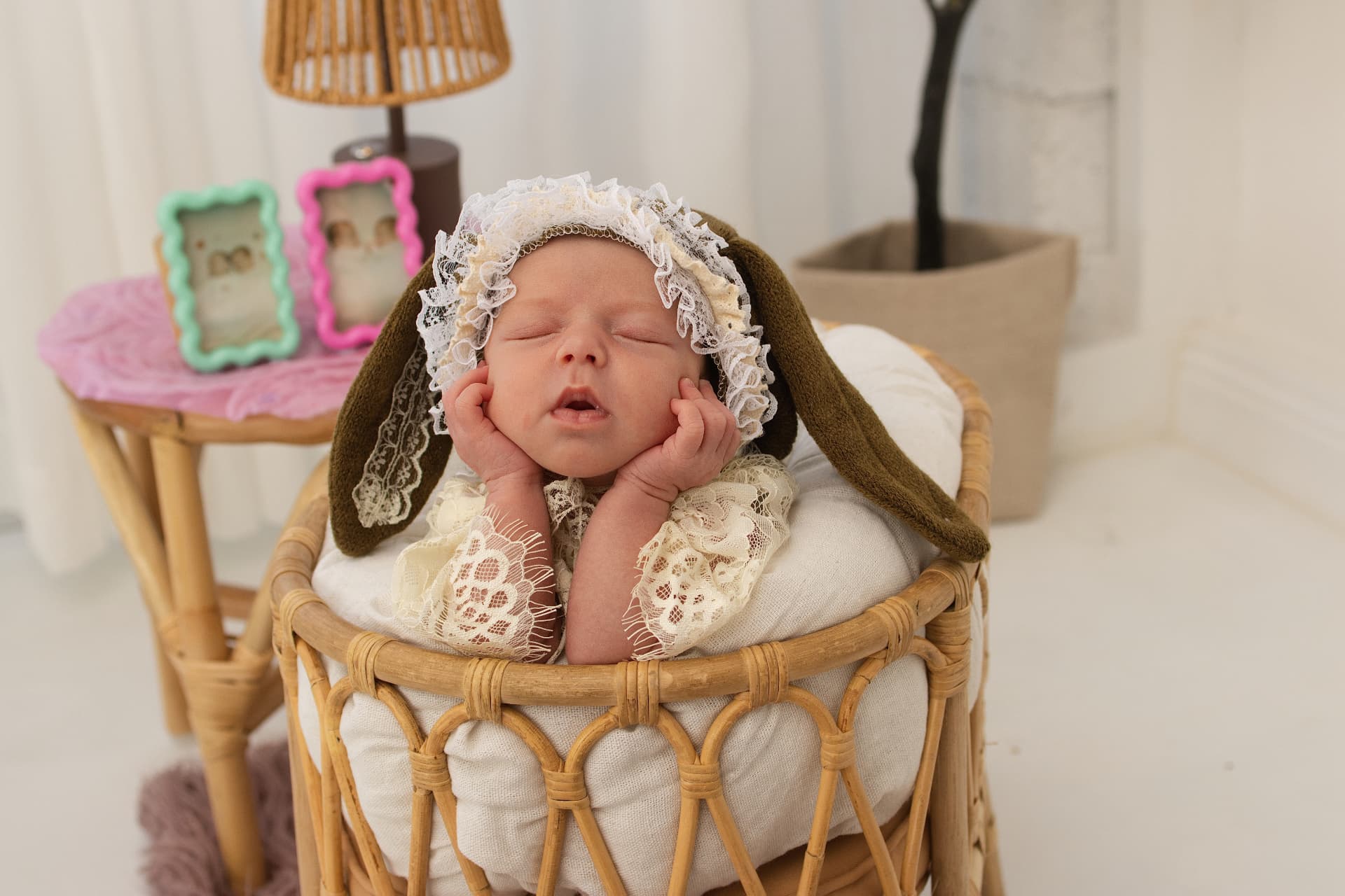 Sleeping newborn resting their chin on their hands in a wicker basket in the Mona Vale studio