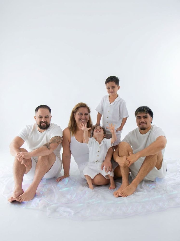 Family of five in white wardrobe on bright clean studio backdrop