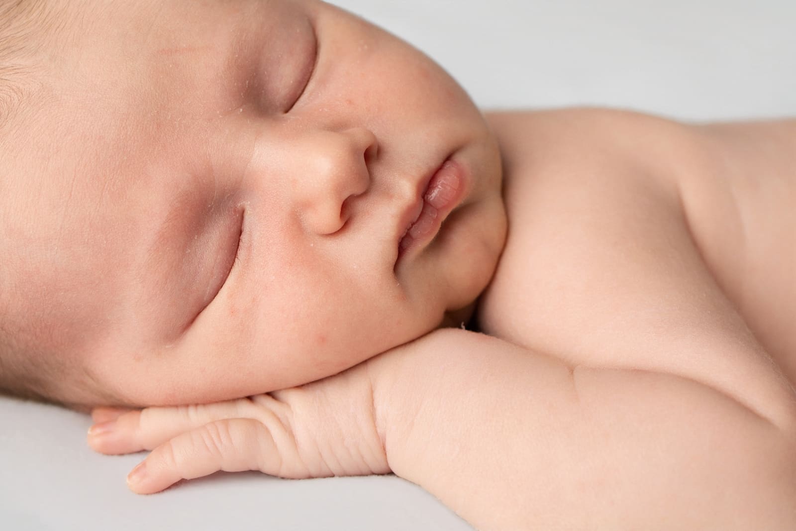 Close-up of a sleeping newborn's face in soft studio light